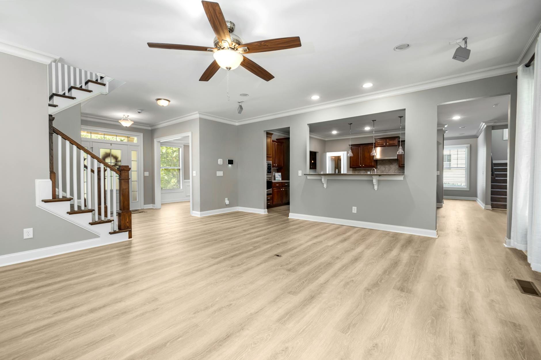 Nowoczesny salon typu open space z drewnianą podłogą i schodami