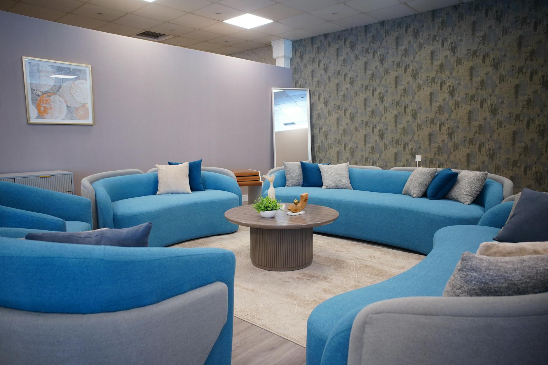 Nowoczesny kącik relaksu z niebieskimi sofami przy dużym oknie