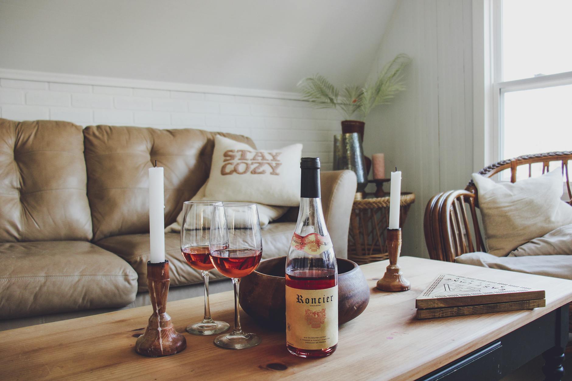 Przytulny salon z kanapą, świecami i kieliszkami wina na stoliku